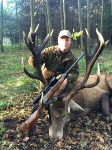 great stag trophy with hunter in forest